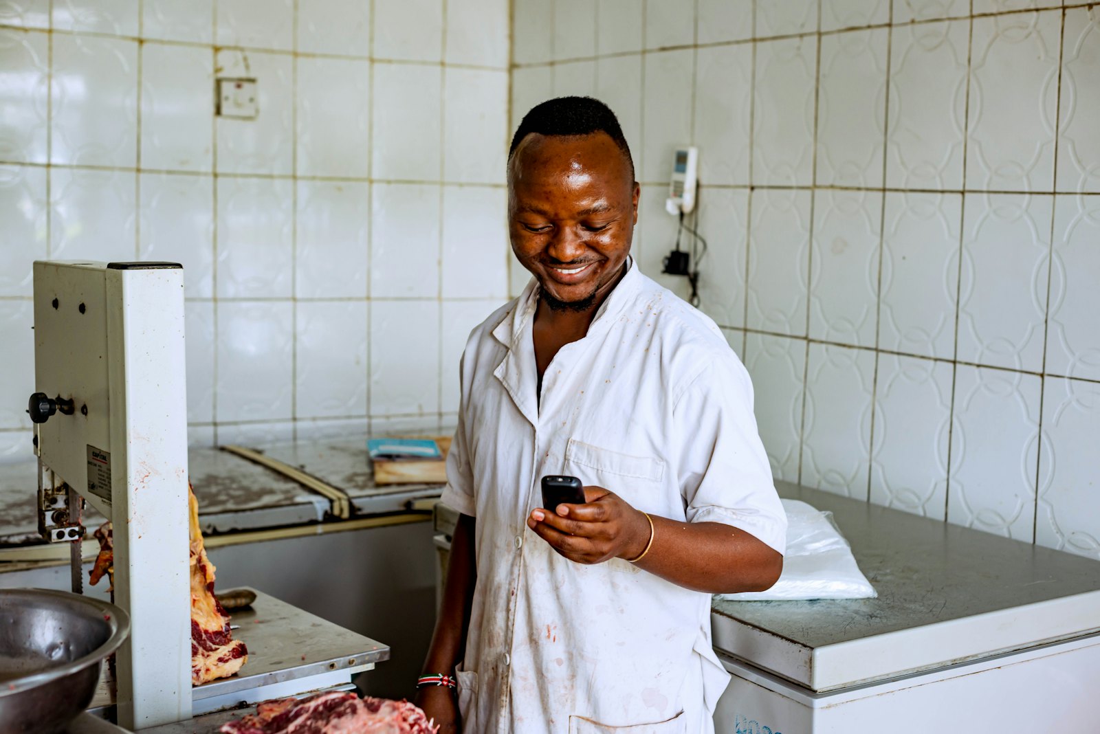 A business owner smiling at a payment notification on his phone