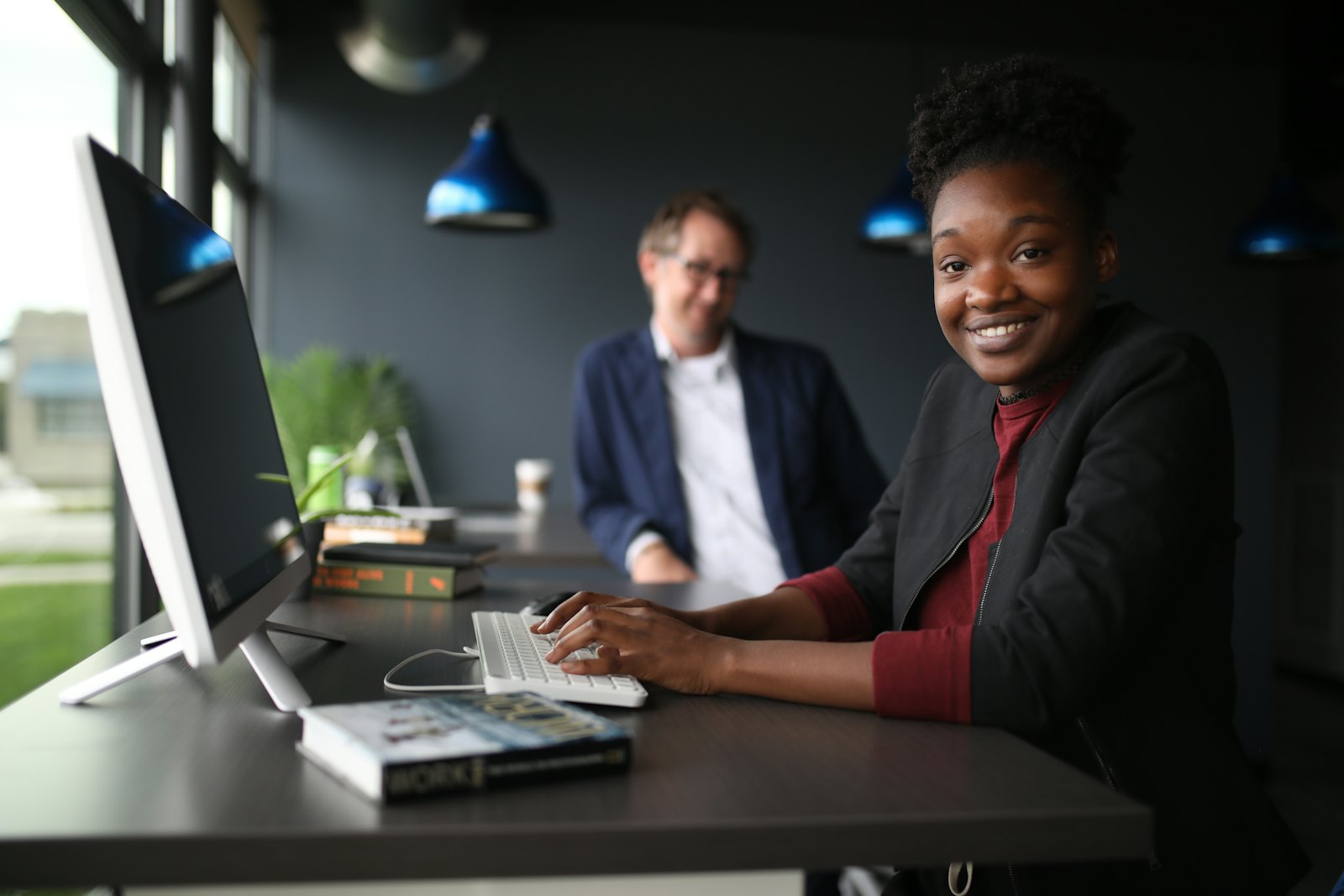 Two colleagues working at a computer in an office
