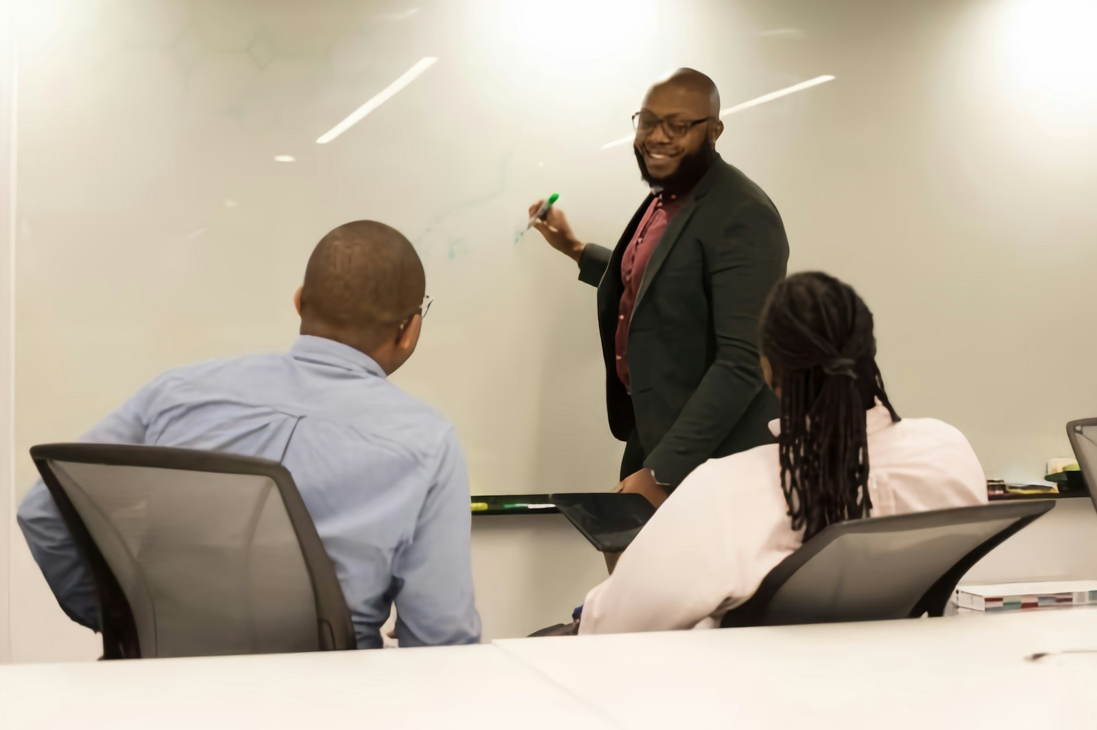 A facilitator teaching a small group at a whiteboard